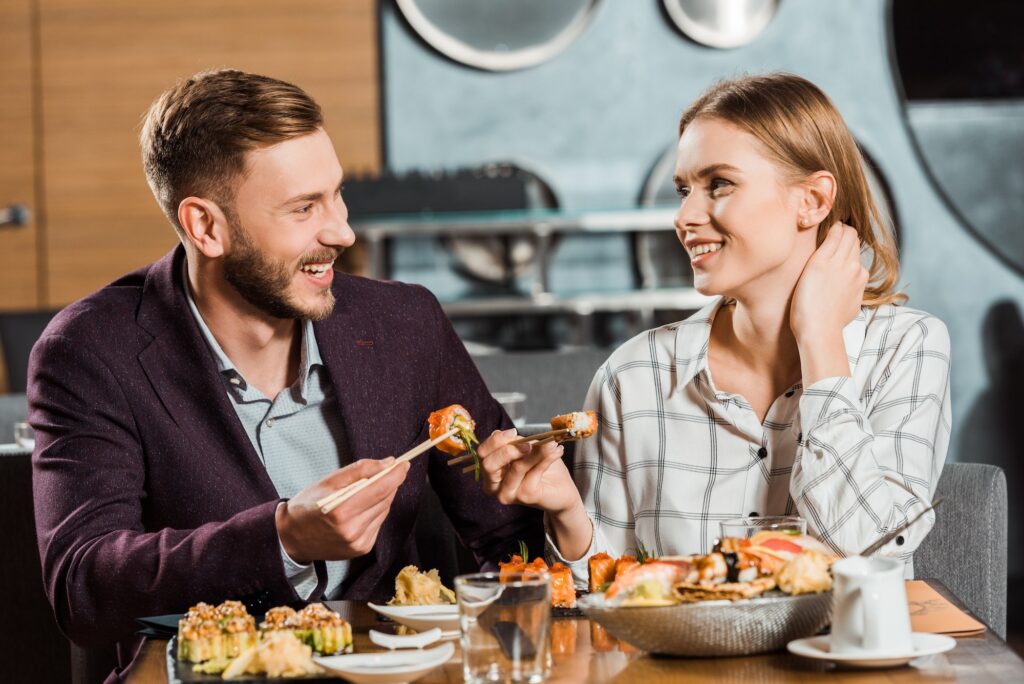 Attractive smiling couple having dinner in restaurant