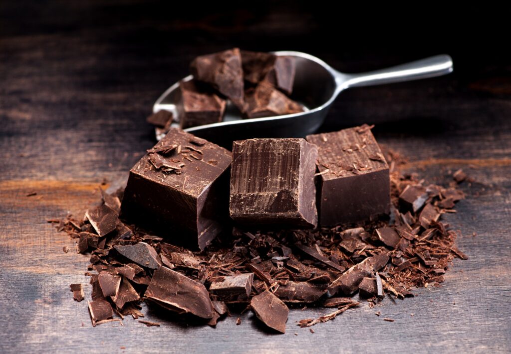 Pieces and chopped chocolate on a dark wooden background heart health 