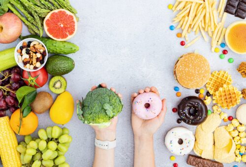 Flat lay of Healthy and unhealthy food from fruits and vegetables vs fast food, sweets and pastry