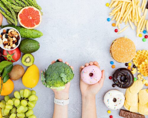 Flat lay of Healthy and unhealthy food from fruits and vegetables vs fast food, sweets and pastry